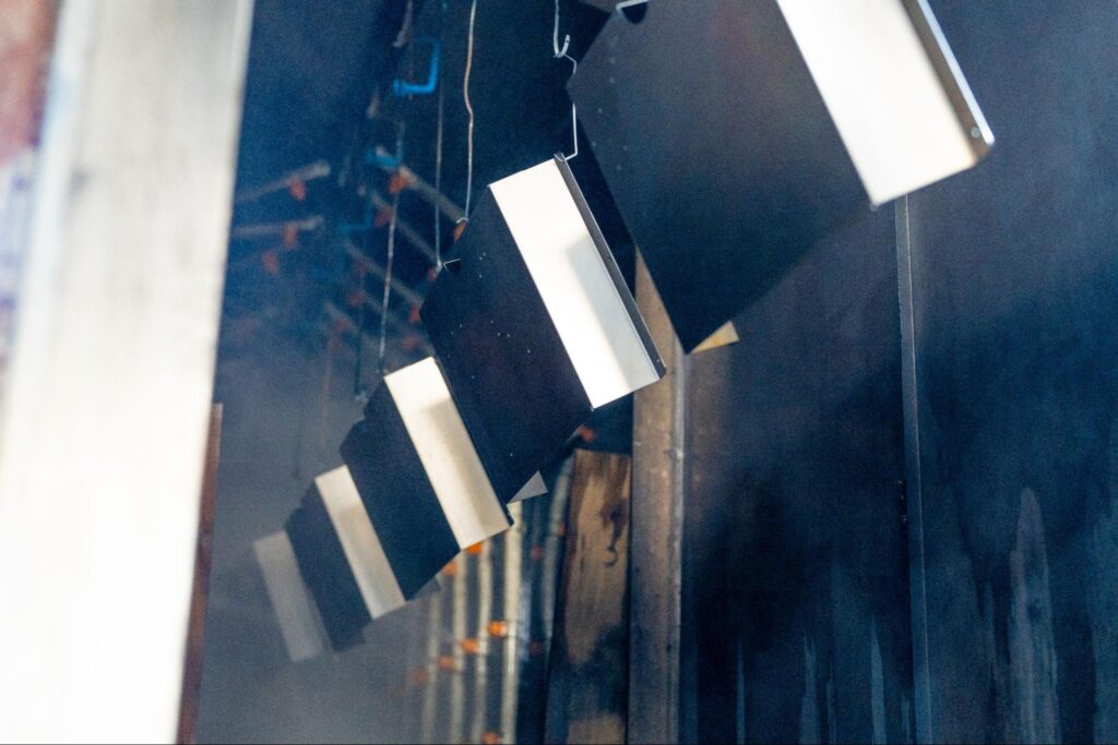 Metal parts hanging in a powder coating or painting process inside Bunty LLC