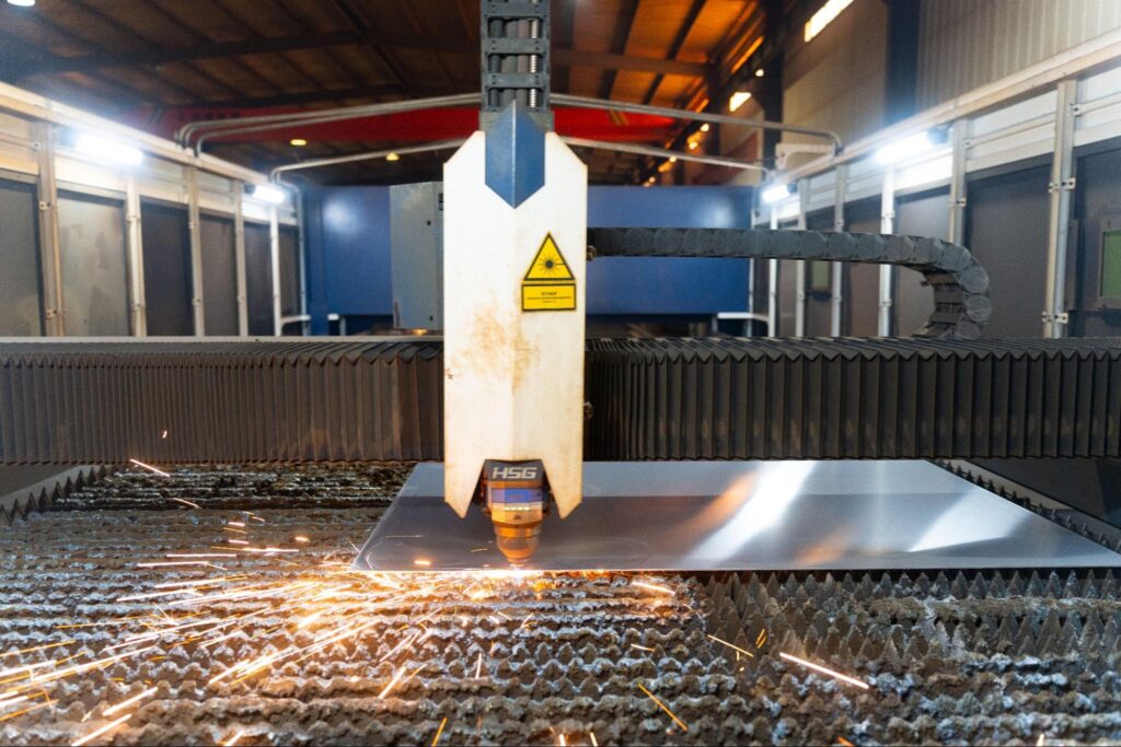 Laser cutting machine emitting sparks while cutting a sheet of metal