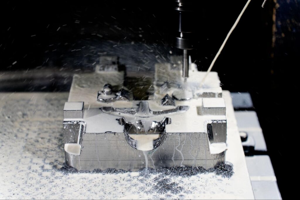 Close-up of CNC milling machine cutting a metal workpiece with coolant spraying